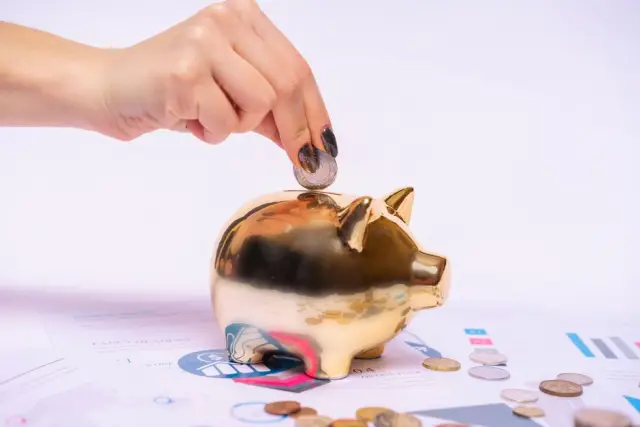 Cofre com moedas sobre planilhas de orçamento